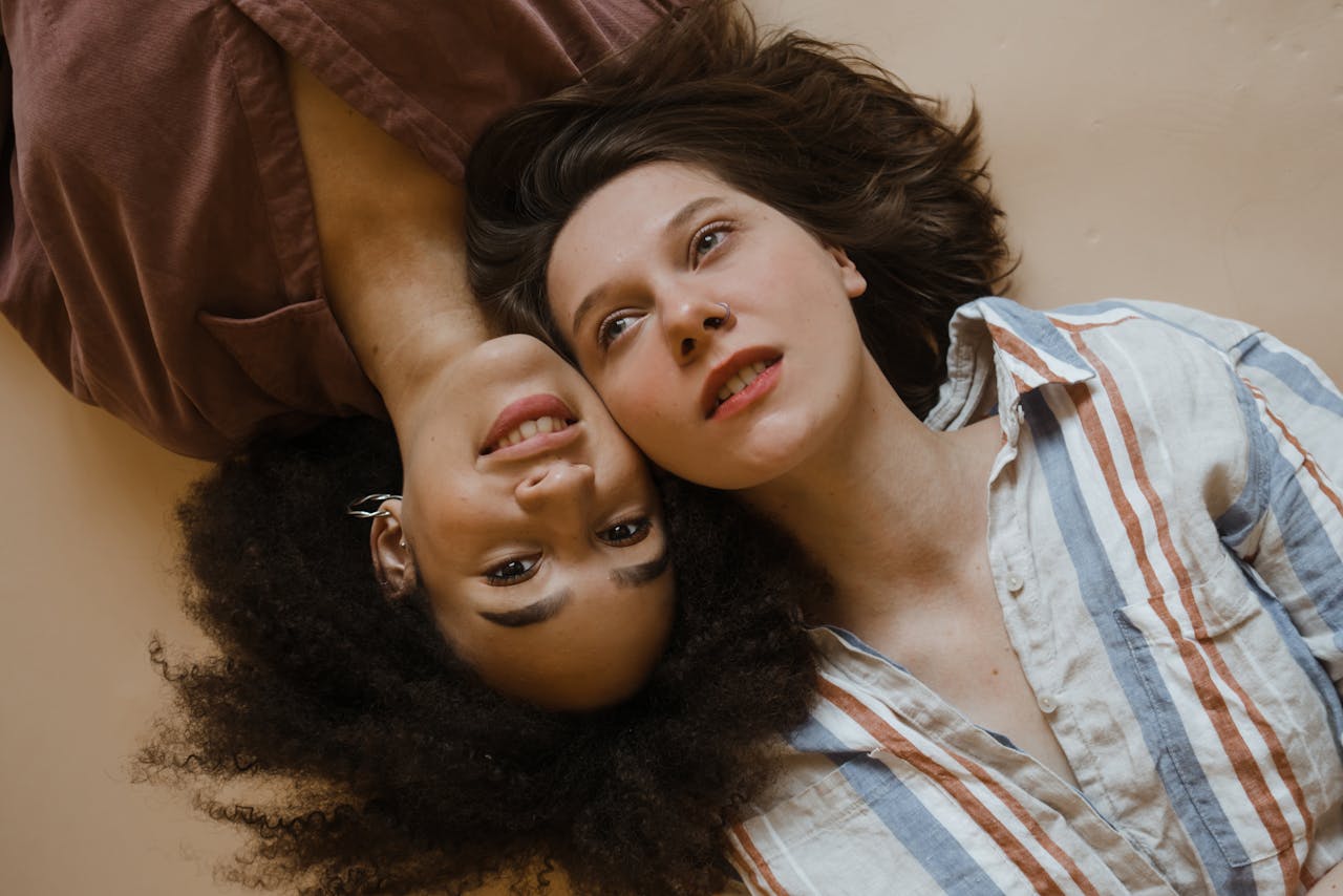 Creative portrait of women with diverse hairstyles lying together, conveying friendship and harmony.
